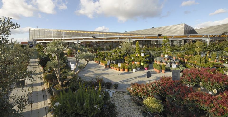 extérieur d'une jardinerie avec une serre de vente